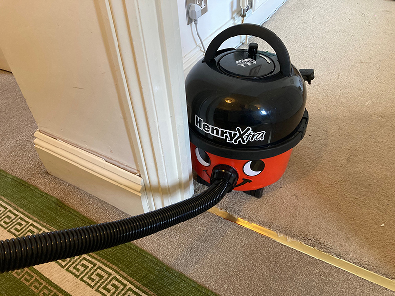 Henry Xtra vacuum cleaner bumping into a door frame