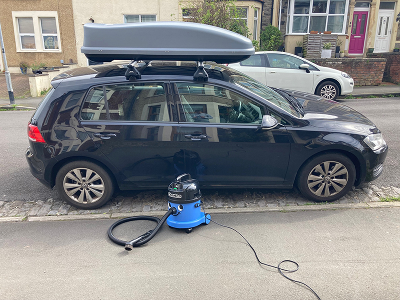 A Charles vacuum being used to clean a car