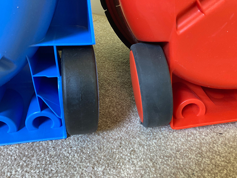 The missing rubber coating on Charles vacuum cleaner's rear wheels, compared to Henry vacuum