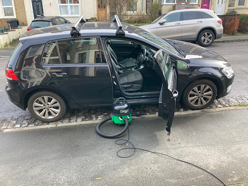 Cleaning a car with a Henry Pet vacuum cleaner.