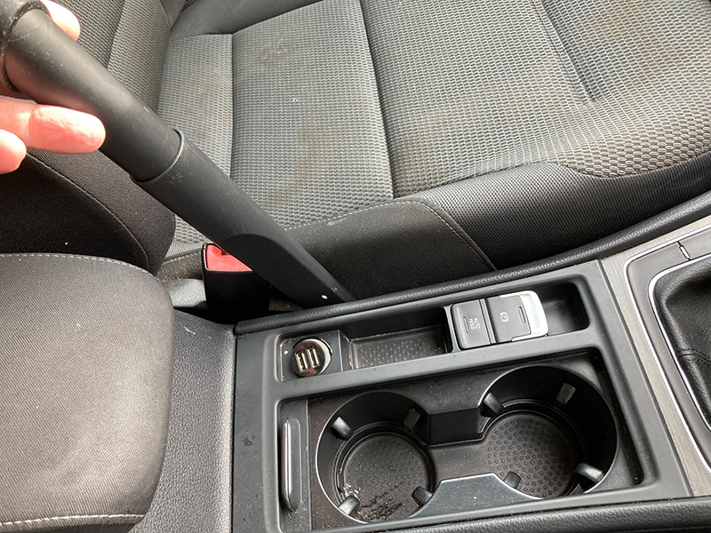 The crevice tool for the Henry Pet being used to clean a car.