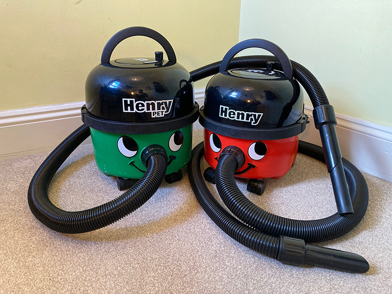 A Henry vacuum cleaner next to a Henry Pet vacuum cleaner.