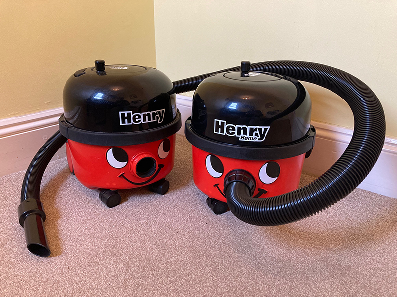 A Henry Home vacuum cleaner next to a Henry vacuum cleaner